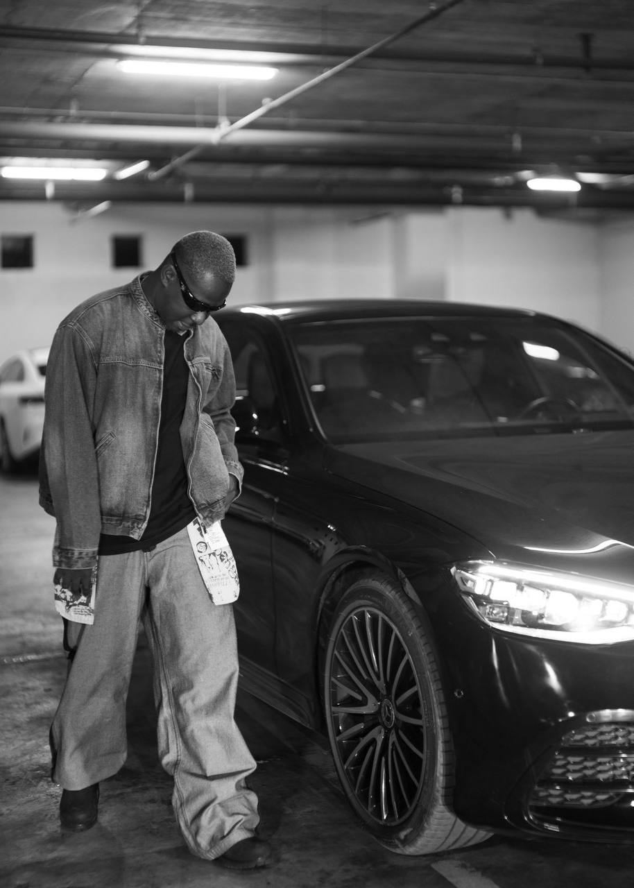 Lenko Psycho beside a black Mercedes in a car park
